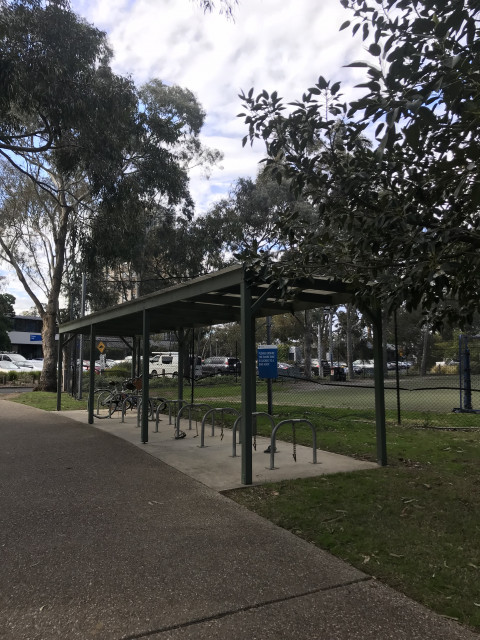 Bike racks located next to basketball court, at top of stairs on College Walk