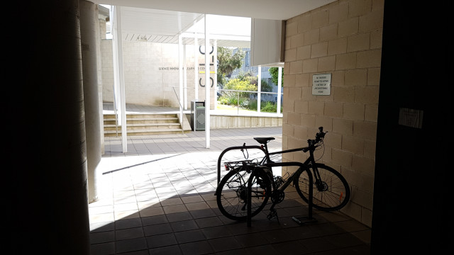 Bike racks on the corner of the IST building with SILC in the background.
