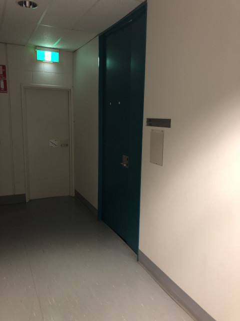 Blue door at end by exit stairs