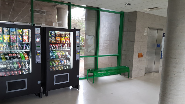 Cold beverage vending machine beside elevator.