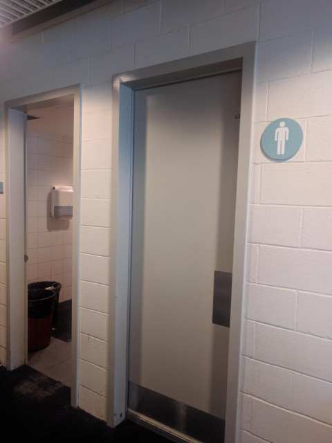 Door on the left, next to male toilets