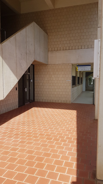 Entrance is that glass doorway under the stairs.