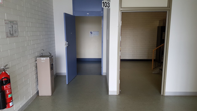 Entrance to lecture theatre 103 beside the southeast staircase.