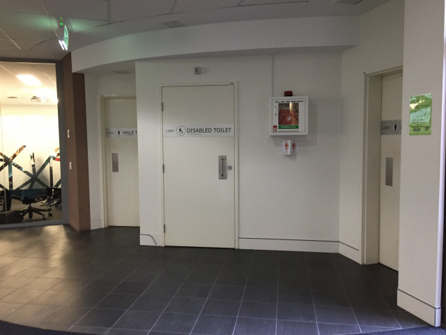 Located between the male and female toilets.