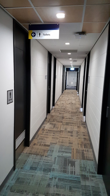 Male toilet looking down the north hallway from the northeast corner.