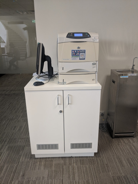 Printer located near the water bubbler and toilets