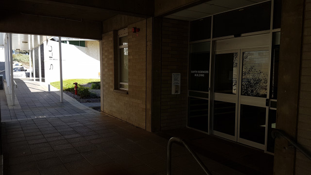 Security intercom panel with clear instructions in front of entrance to the Earth Sciences Building.