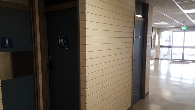 Unisex shower with entrance in background.